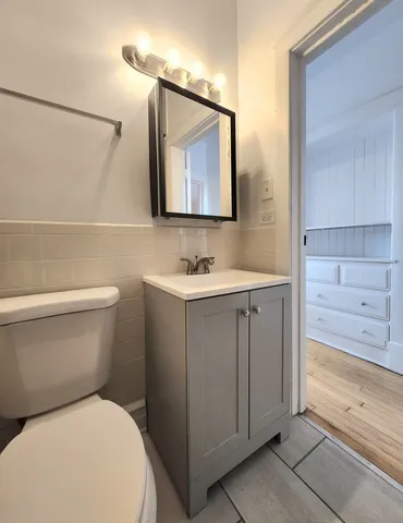 a bathroom with a toilet sink and mirror