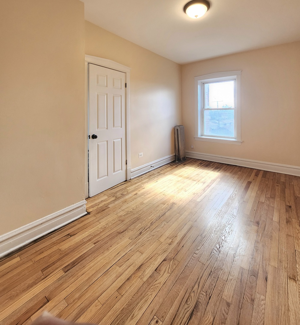 4937 West 18th Street, Unit 2W Cicero, IL 60804 - Photo 10 of 11 an empty room with wooden floor and windows