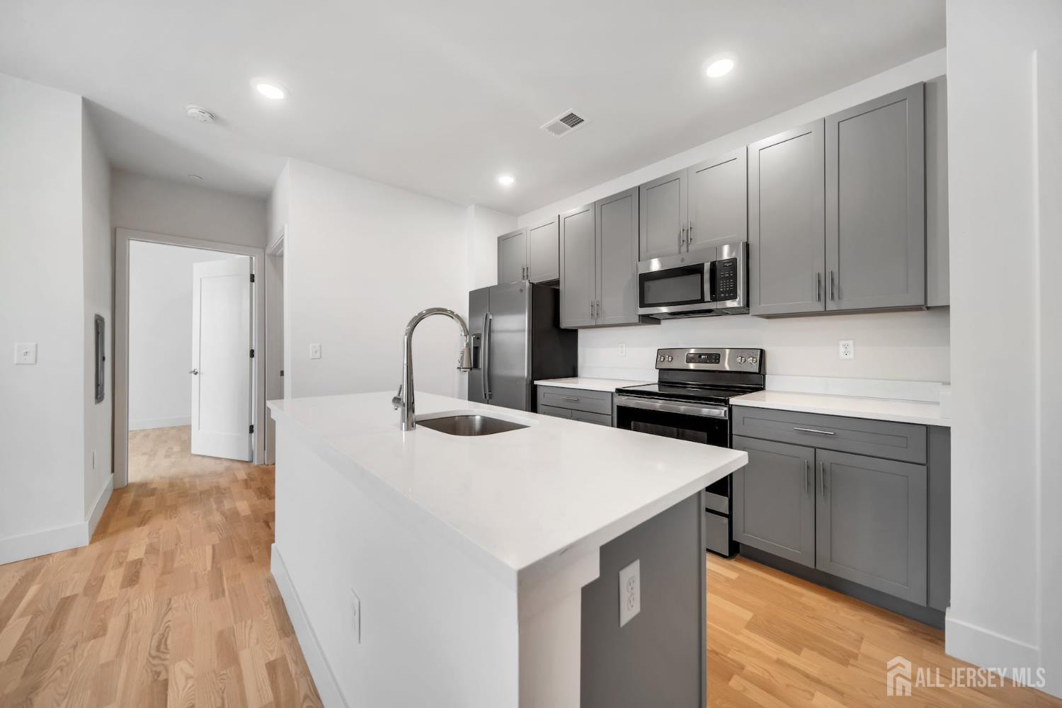 1037 Amboy Avenue Edison, NJ 08837 - Photo 2 of 5 a kitchen with a sink a stove and cabinets