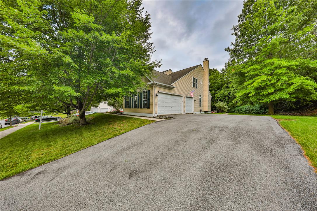 138 Clover Hollow Road Easton, PA 18045 - Photo 3 of 95 A welcoming asphalt driveway leads to a classic residence framed by verdant trees and ample yard space.