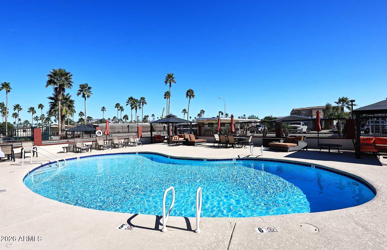 9302 East Broadway Road, Unit 76 Mesa, AZ 85208 - Photo 14 of 38 a view of a swimming pool with outdoor seating