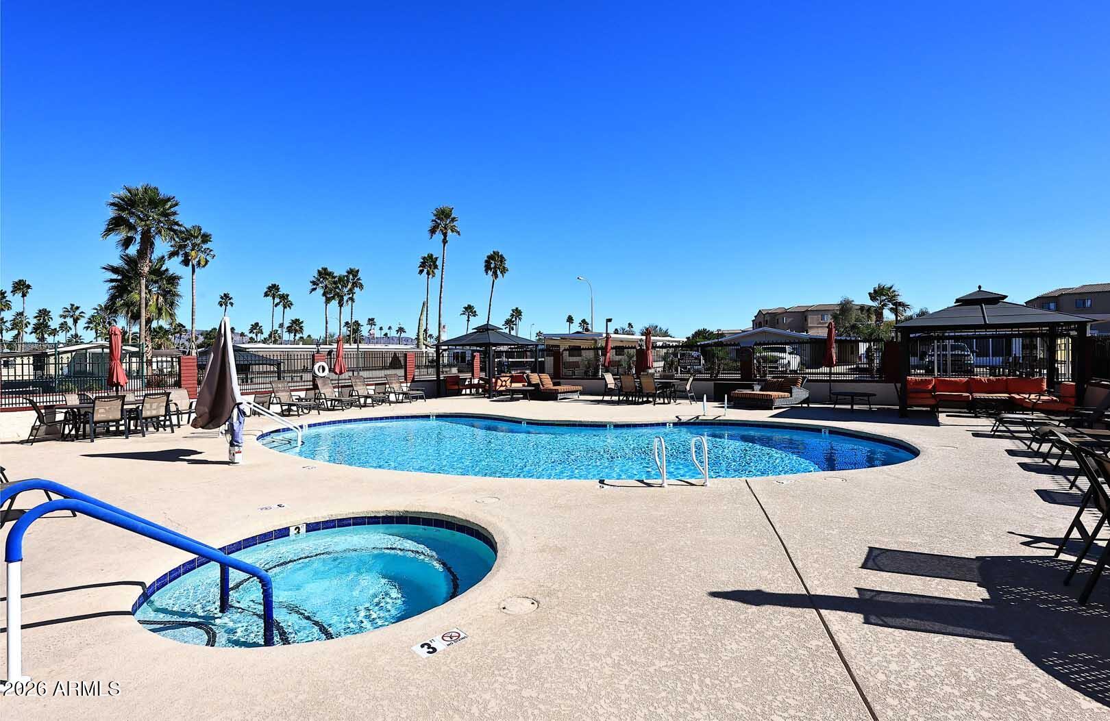 9302 East Broadway Road, Unit 76 Mesa, AZ 85208 - Photo 15 of 38 a view of a swimming pool with outdoor seating