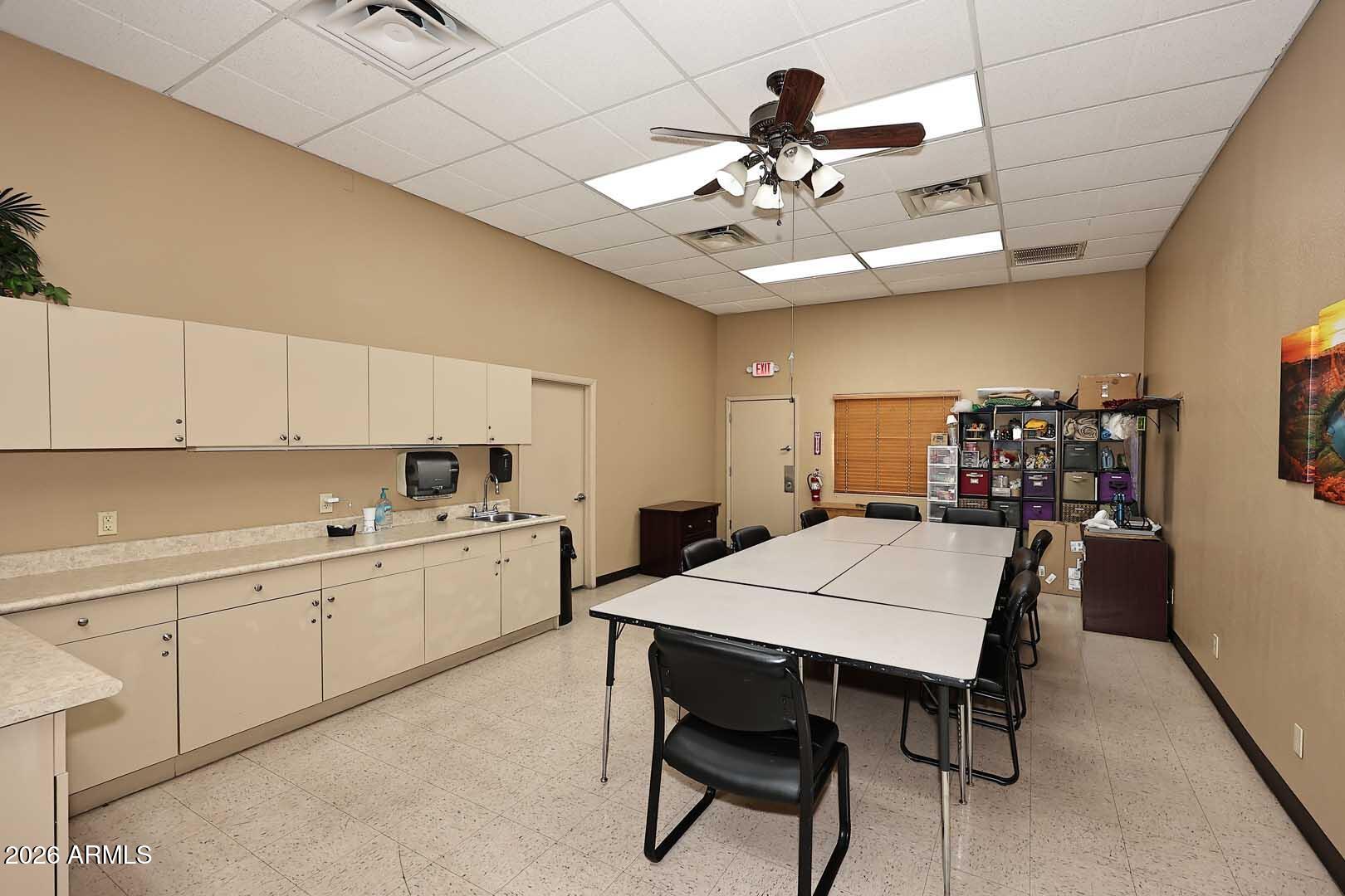 9302 East Broadway Road, Unit 76 Mesa, AZ 85208 - Photo 23 of 38 a kitchen with a dining table chairs sink and cabinets