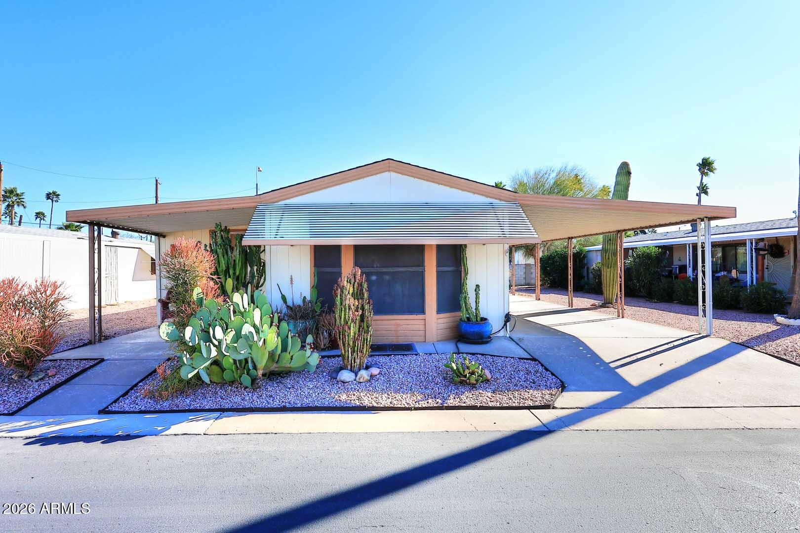 9302 East Broadway Road, Unit 76 Mesa, AZ 85208 - Photo 35 of 38 a front view of a house with garden