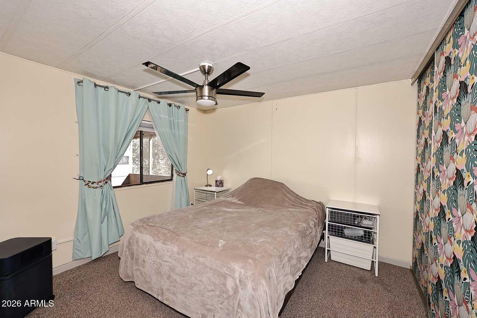 9302 East Broadway Road, Unit 76 Mesa, AZ 85208 - Photo 4 of 38 a bedroom with a bed and a chandelier