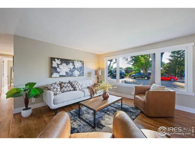 a living room with furniture potted plant and a large window