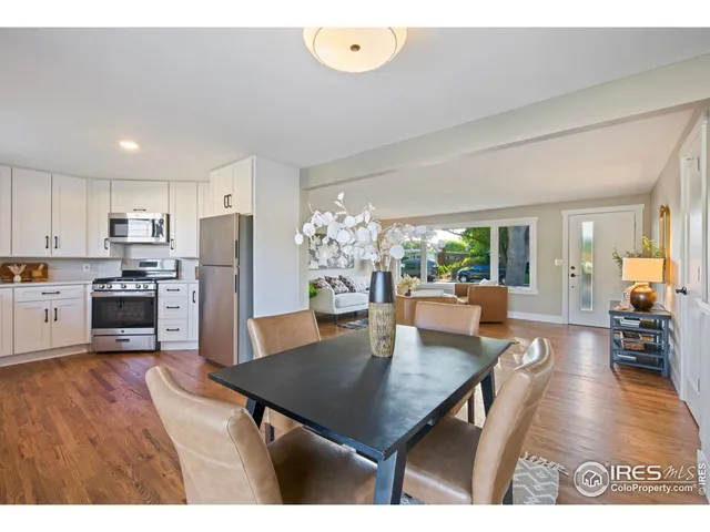 a kitchen with a table chairs refrigerator and dining table