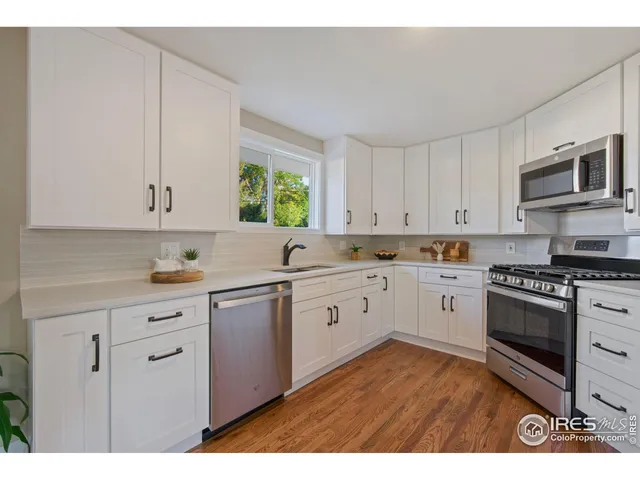 a kitchen with granite countertop white cabinets stainless steel appliances and sink