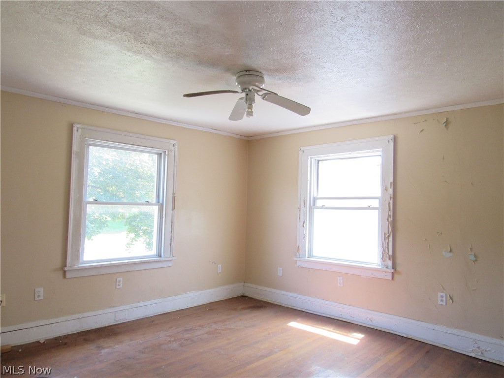 1726 Lee Road Cleveland Heights, OH 44118 - Photo 23 of 36 Room featuring two windows with white trim, a ceiling fan, and wood-finish flooring