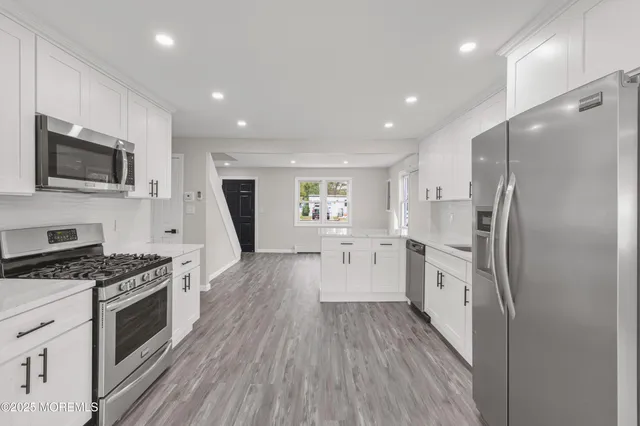 a view of a hallway with wooden floor and furniture
