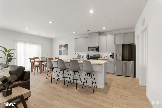a kitchen with a dining table chairs and wooden floor