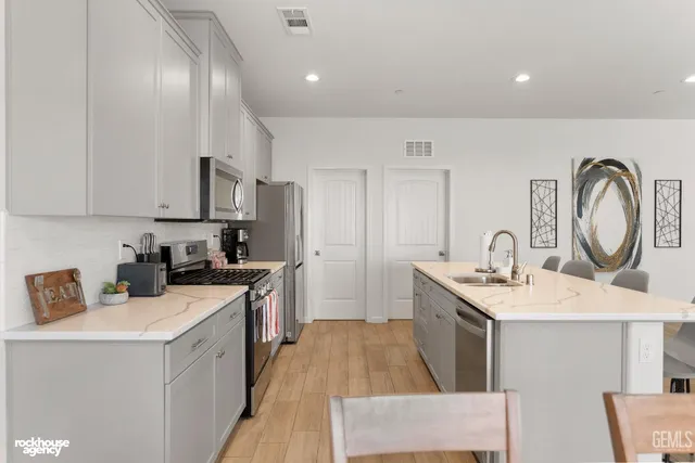 a kitchen with a dining table chairs and white appliances