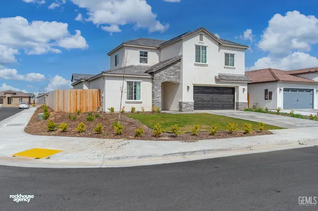 a view of a white house with a swimming pool and a yard