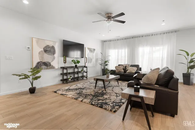 a living room with lots of furniture and a wooden floor