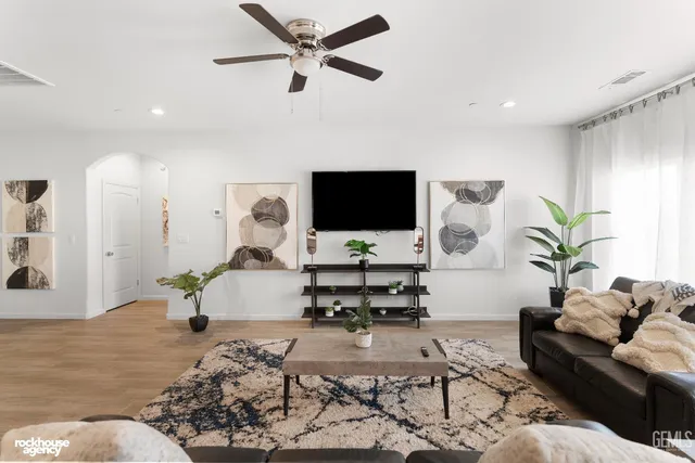 a living room with furniture kitchen view and a chandelier