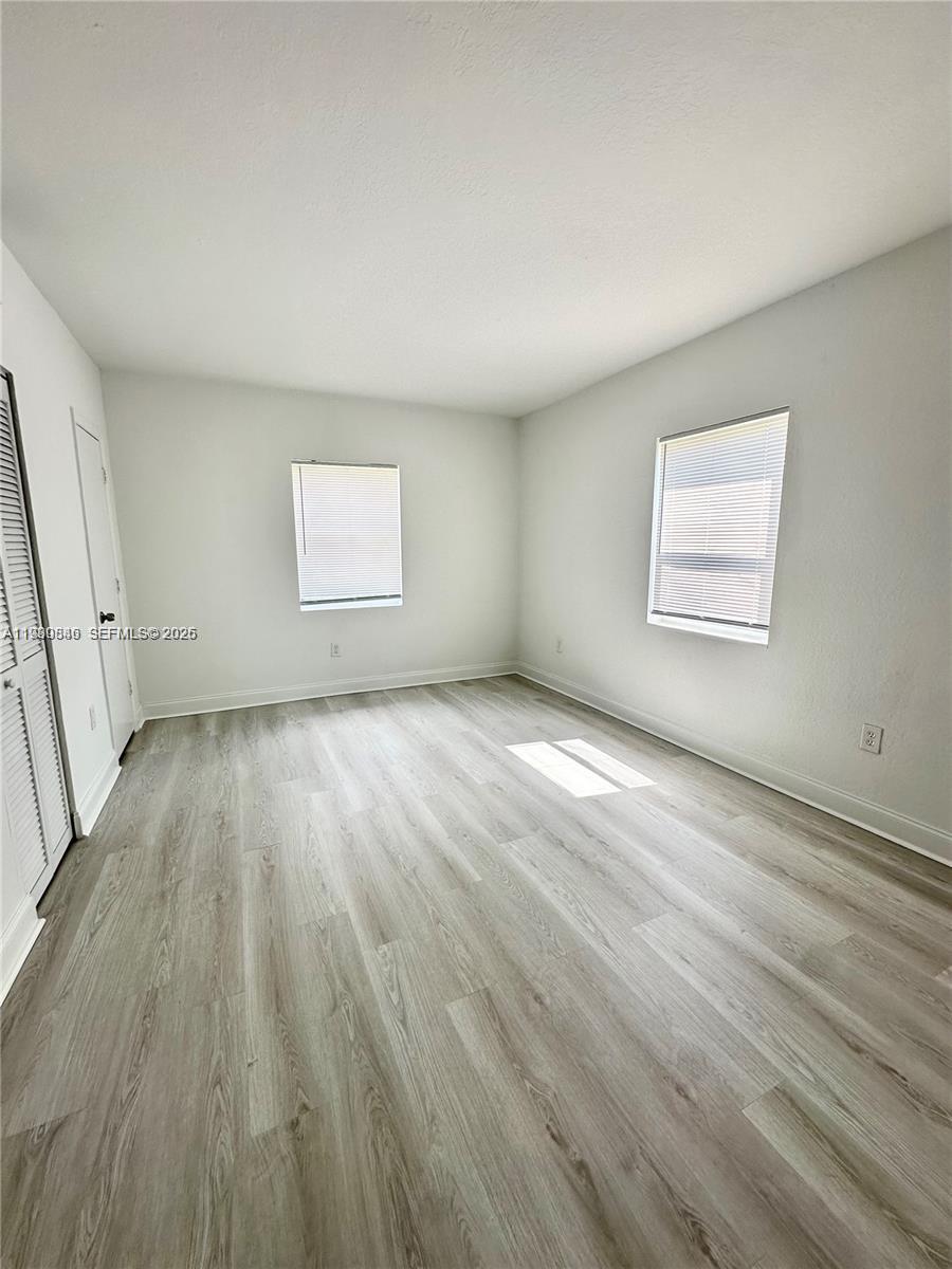 434 Northwest 85th Street Road, Unit 434 Miami, FL 33150 - Photo 13 of 31 an empty room with wooden floor and windows