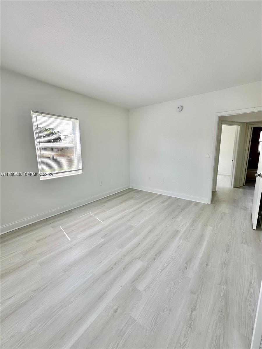 434 Northwest 85th Street Road, Unit 434 Miami, FL 33150 - Photo 14 of 31 a view of an empty room with wooden floor and a window