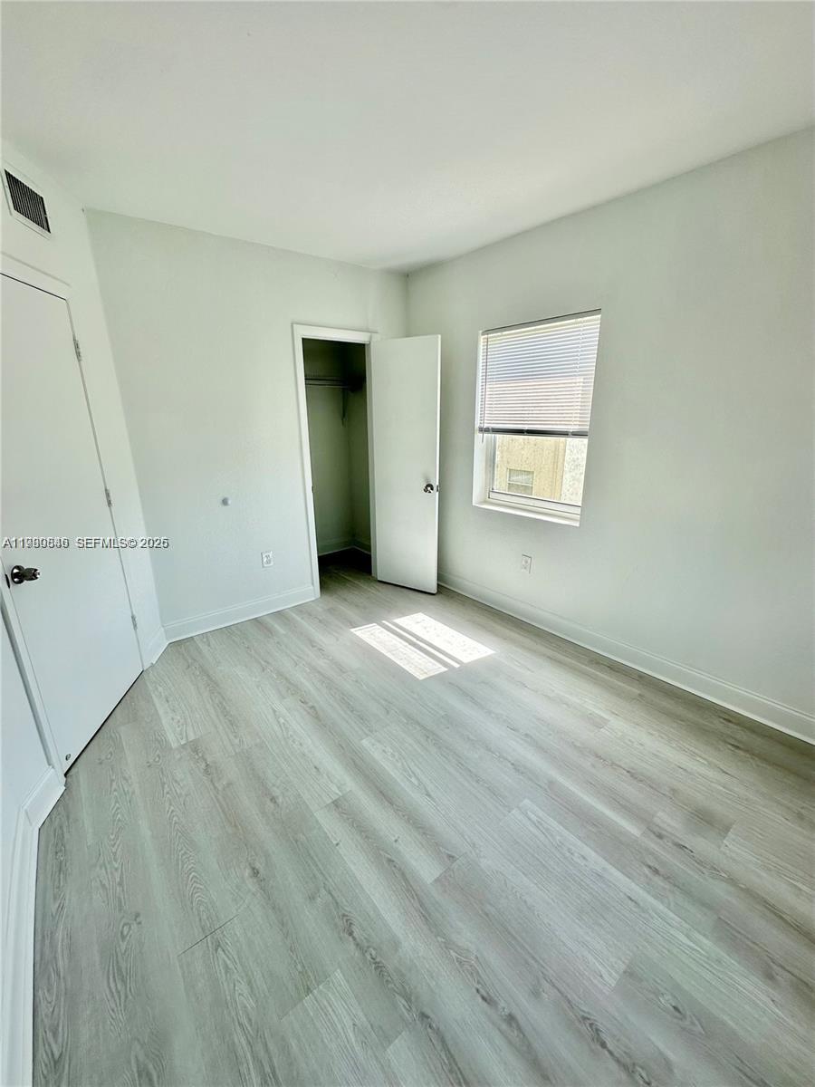 434 Northwest 85th Street Road, Unit 434 Miami, FL 33150 - Photo 17 of 31 a view of an empty room with wooden floor and a window