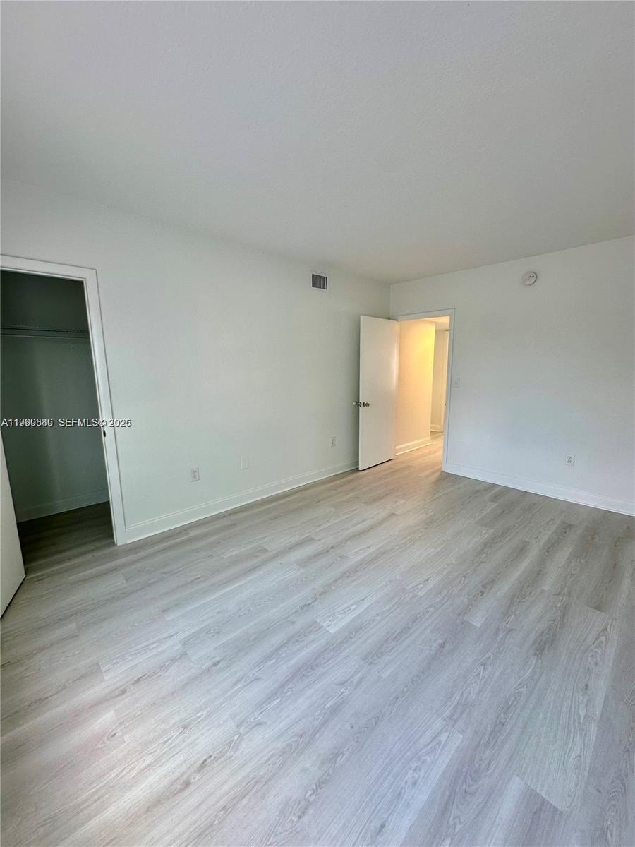 434 Northwest 85th Street Road, Unit 434 Miami, FL 33150 - Photo 18 of 31 an empty room with wooden floor and windows