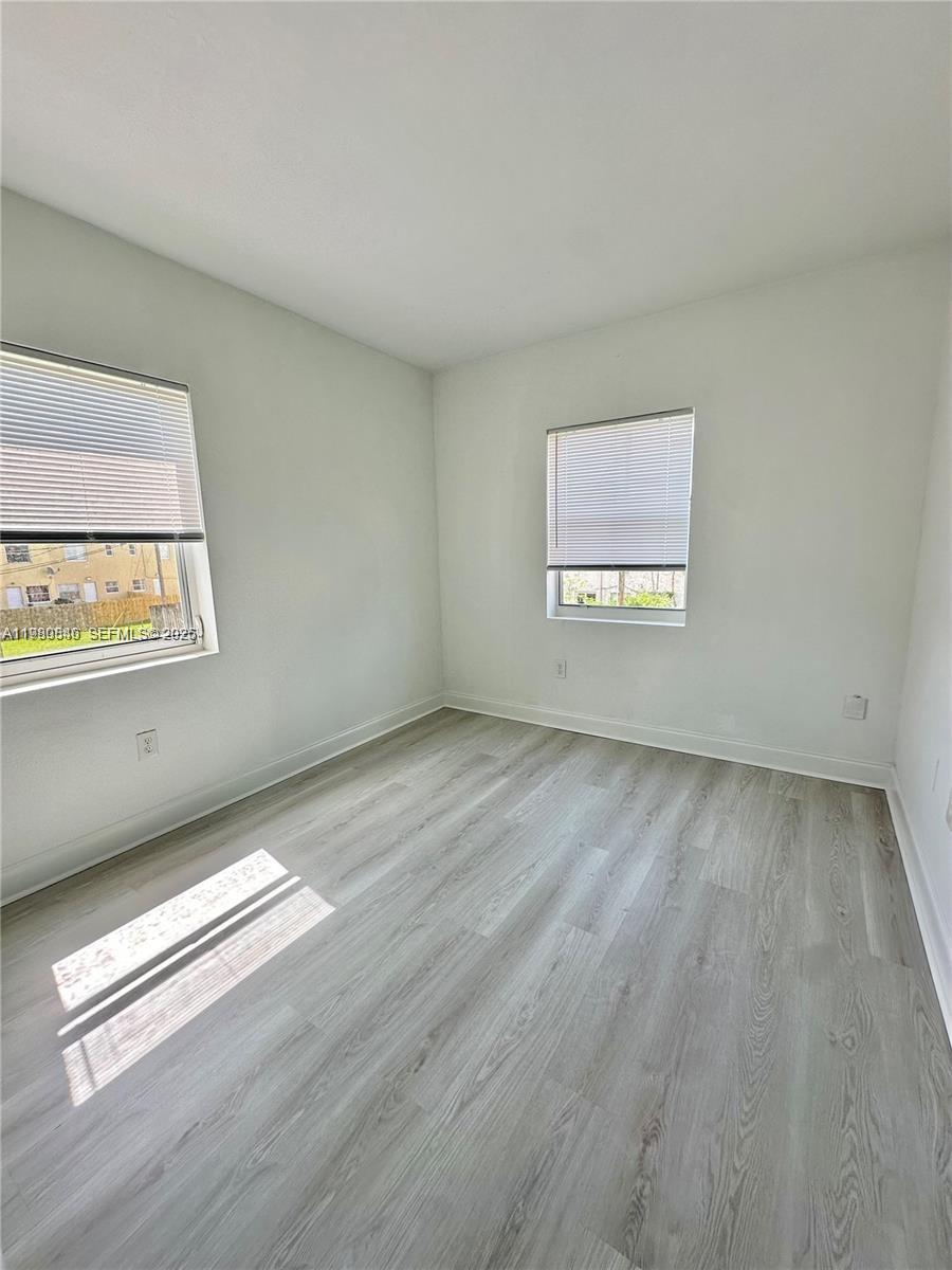 434 Northwest 85th Street Road, Unit 434 Miami, FL 33150 - Photo 19 of 31 an empty room with wooden floor and windows