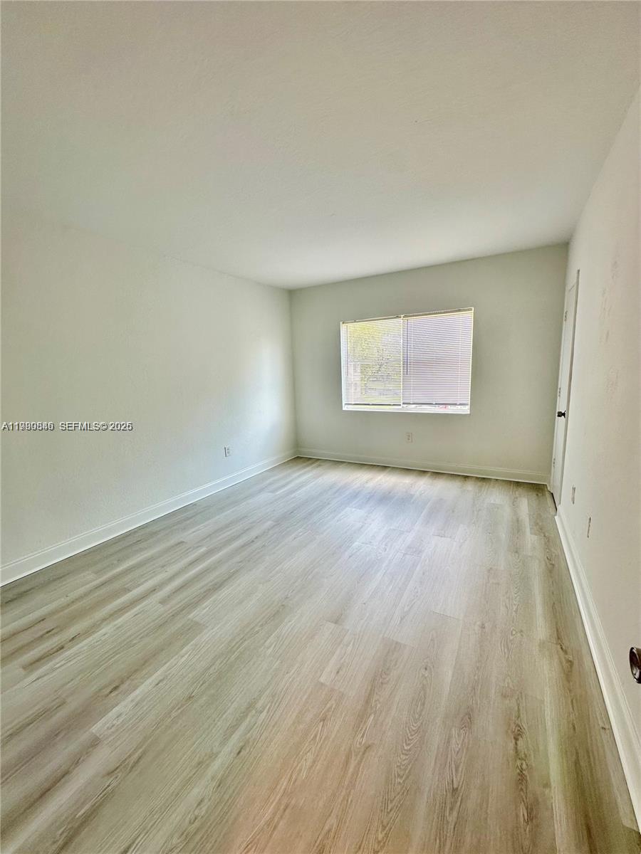 434 Northwest 85th Street Road, Unit 434 Miami, FL 33150 - Photo 20 of 31 an empty room with wooden floor and windows