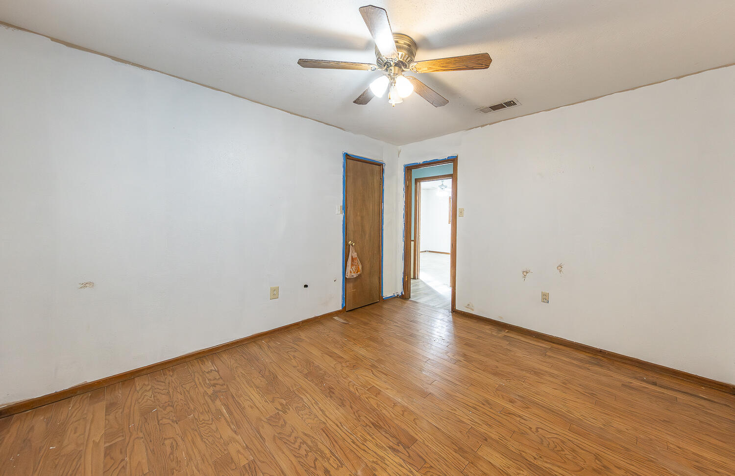 505 Owen Street Lubbock, TX 79403 - Photo 18 of 32 an empty room with wooden floor chandelier fan and windows