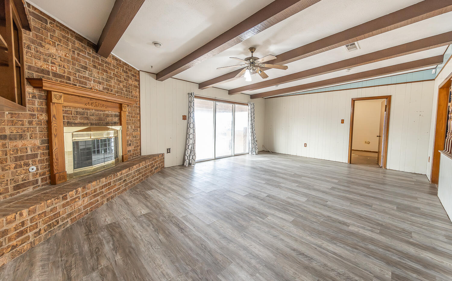 505 Owen Street Lubbock, TX 79403 - Photo 2 of 32 a view of an empty room with wooden floor and a window