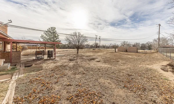 a view of a dry yard with wooden fence