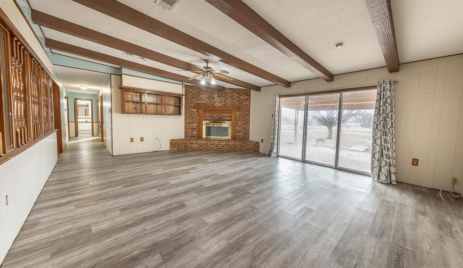 505 Owen Street Lubbock, TX 79403 - Photo 6 of 32 a view of an empty room with wooden floor and a window
