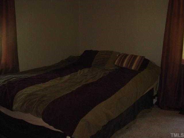 5501 Meadowbrook Road Raleigh, NC 27603 - Photo 7 of 9 a bed sitting in a bedroom next to a window