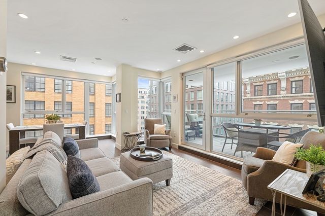 a living room with furniture and floor to ceiling windows