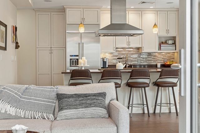 a kitchen with stainless steel appliances kitchen island granite countertop a table and chairs in it