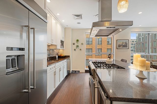 a kitchen with stainless steel appliances granite countertop a stove a washer and dryer