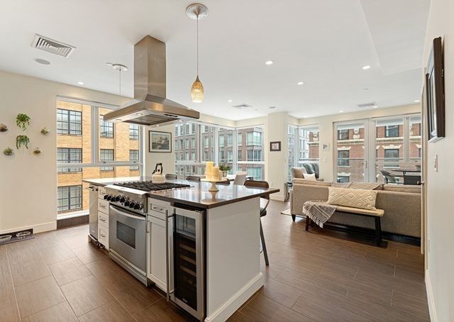 a kitchen with stainless steel appliances granite countertop a stove and a wooden floors
