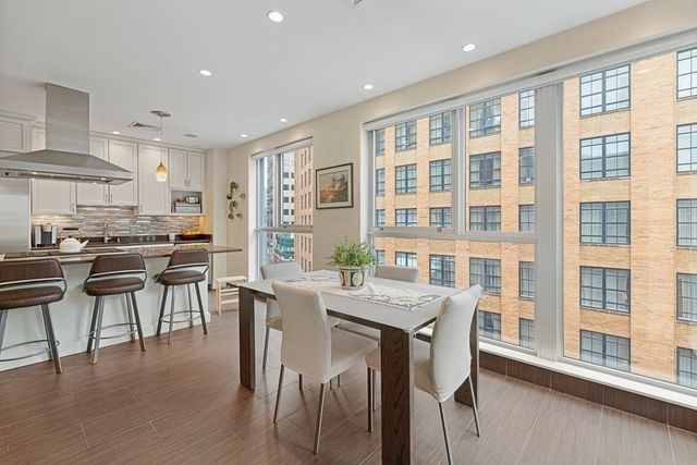 a dining room with stainless steel appliances kitchen island granite countertop a dining table and chairs
