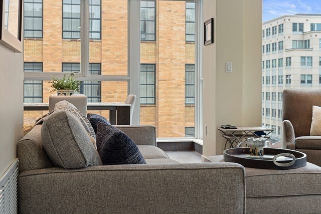 a living room with furniture and a floor to ceiling window