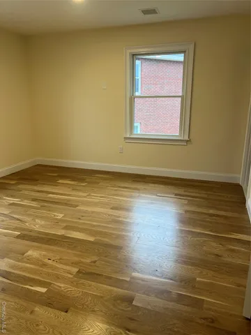 a view of a room with wooden floor and windows