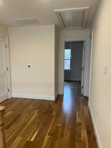 a view of a room with wooden floor and a hallway
