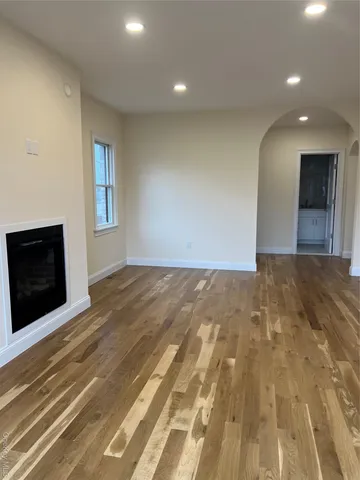 a view of an empty room with a fireplace and a window