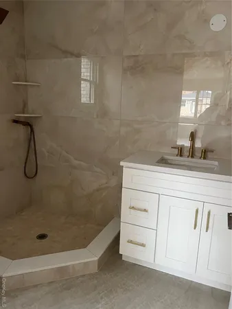 a bathroom with a granite countertop sink a toilet and shower