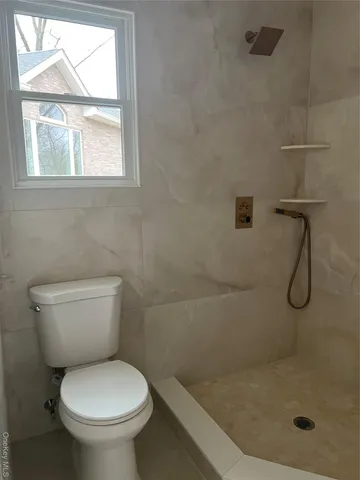 a bathroom with a toilet and a shower