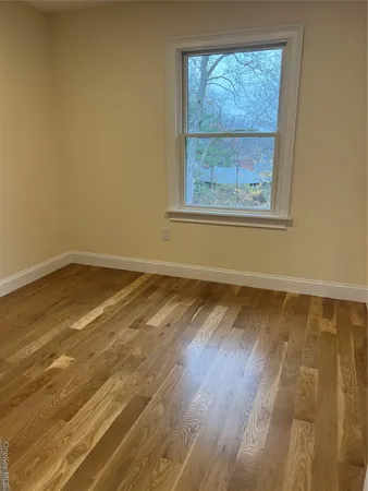 a view of a room with wooden floor and a window