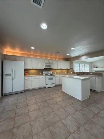 a large kitchen with a lot of cabinets and a sink