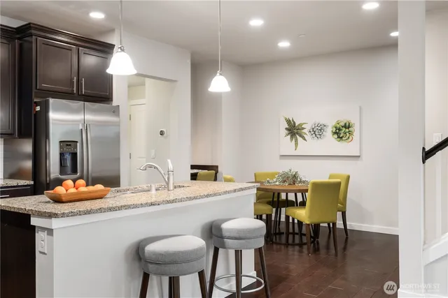 a kitchen with stainless steel appliances granite countertop a sink a stove a refrigerator and island