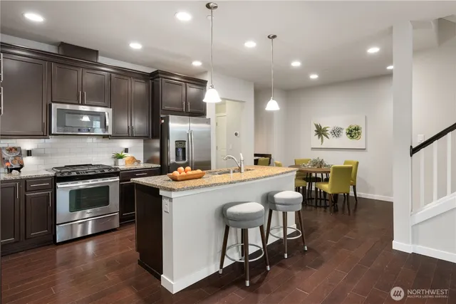 a dining room with stainless steel appliances kitchen island a table and chairs