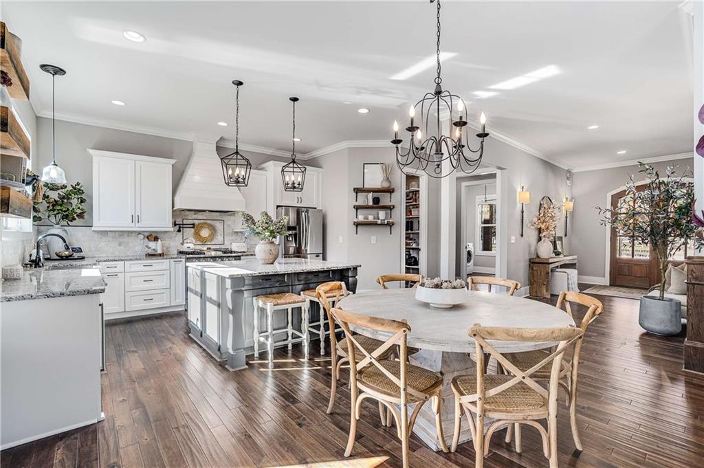 9245 Brumbelow Road Alpharetta, GA 30022 - Photo 12 of 50 a kitchen with stainless steel appliances kitchen island granite countertop a dining table chairs and white cabinets