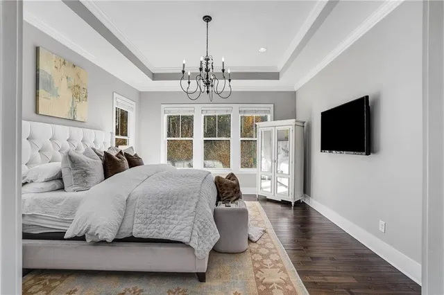 a bedroom with a bed wooden floor and flat screen tv