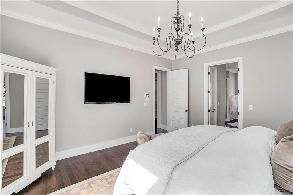 9245 Brumbelow Road Alpharetta, GA 30022 - Photo 21 of 50 a spacious bedroom with a bed and a flat screen tv