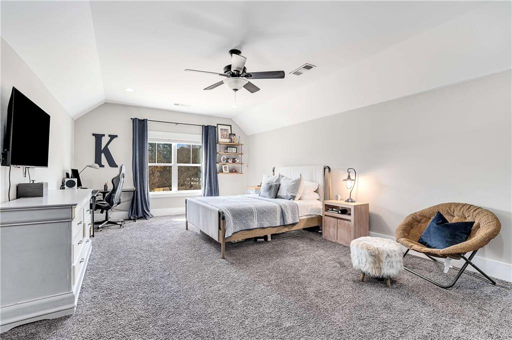 9245 Brumbelow Road Alpharetta, GA 30022 - Photo 33 of 50 a spacious bedroom with a bed and a flat screen tv