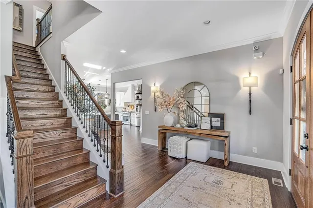 a view of a hallway to a livingroom with wooden floor and furniture